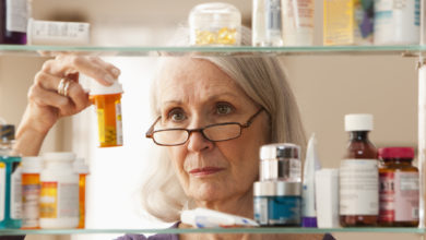 Woman looks at medicine bottle