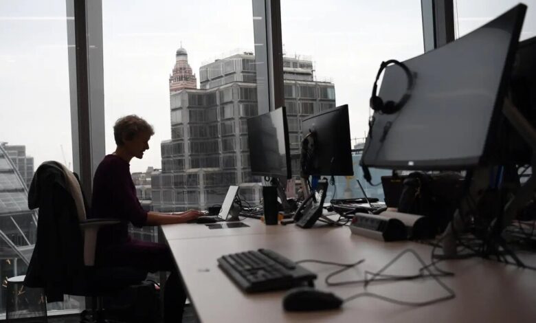 Worker in front of computer in front of big window