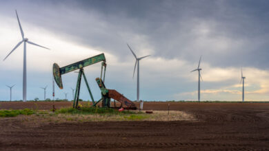 Windmills behind an oil pumpjack in Texas