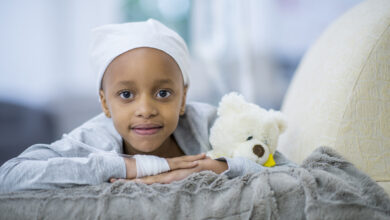 Little Girl With Cancer Sits in a Chair While Receiving her IV Drip Chemotherapy stock photo