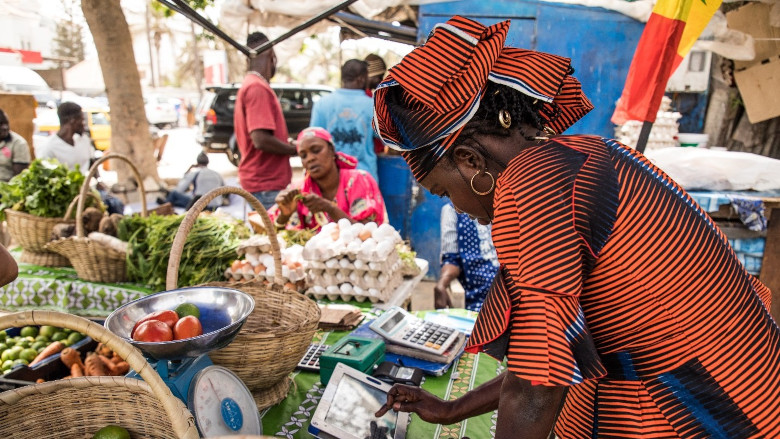 Woman uses tablet on market in Senegal