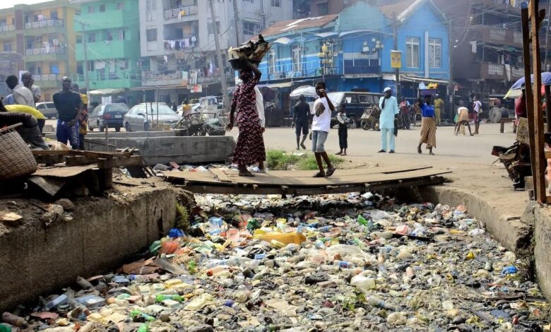 Drainage channel blocked with bottles and styrofoam food containers in Lagos