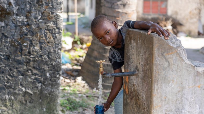 Child gets water from a dwell in Tanzania