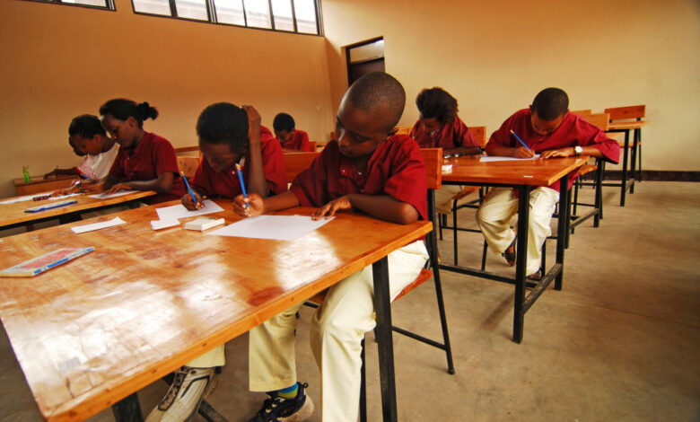 Burundi, Bujumbura, school kids writing exam papers in classroom