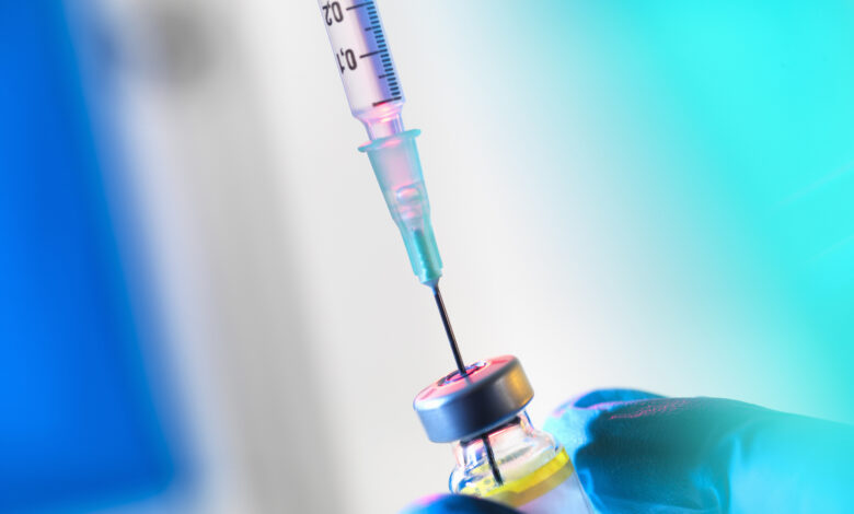 Syringe inserted into a vaccine vial
