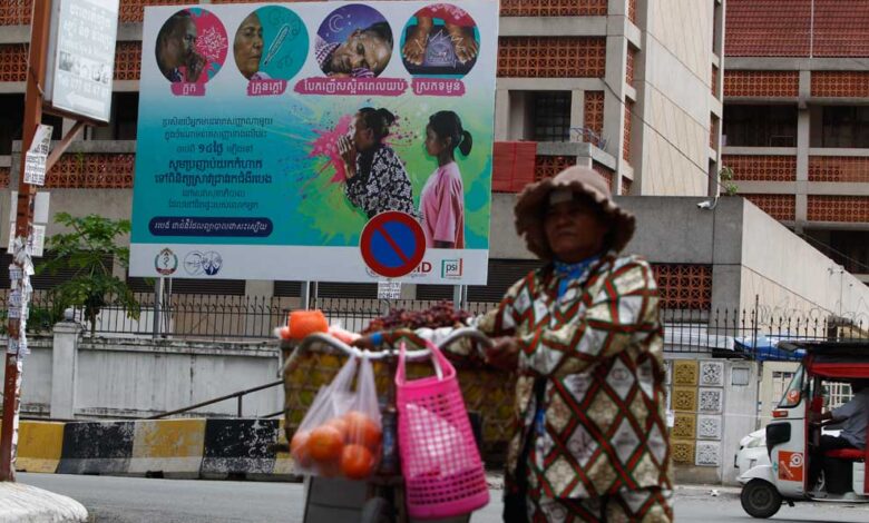 A woman walks her bicycle in front of the National Centre for Tuberculosis and Leprosy Control (CENAT) in Boeung Keng Kang district of the capital in 2021.