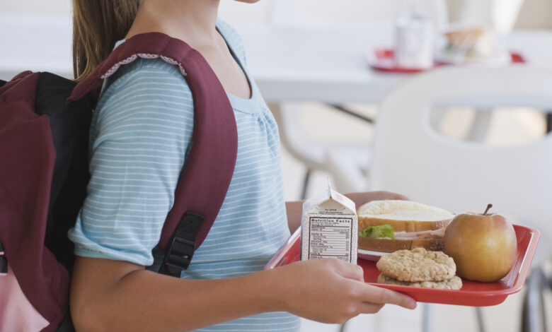 Girl carrying lunch tray at school