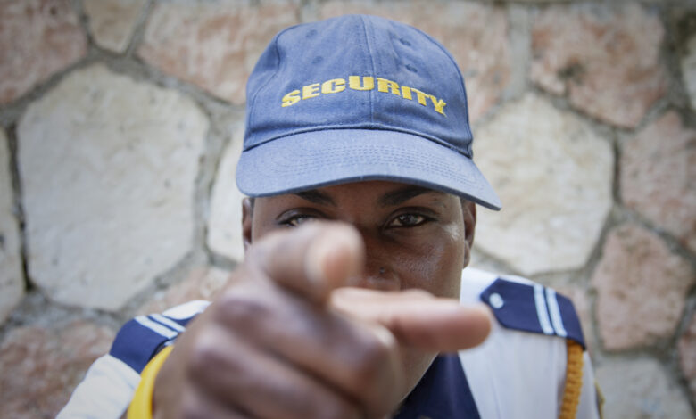 Jamaica. Security guard pointing finger at camera