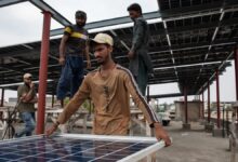 Workers install solar panels on the rooftop of a business on June 30, 2025 in Islamabad, Pakistan.
