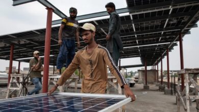 Workers install solar panels on the rooftop of a business on June 30, 2025 in Islamabad, Pakistan.