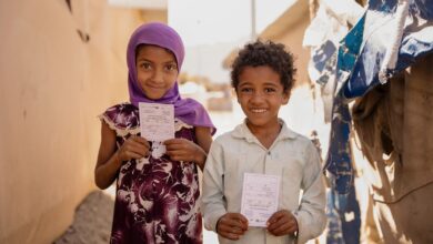 Two children hold their vaccination cards after receiving the oral cholera vaccine in Sannah camp in Al Dhale'e, Yemen.