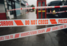 Police white and red cordon tape separating the crime scene.