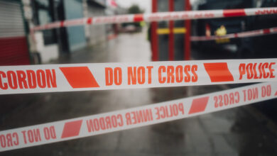 Police white and red cordon tape separating the crime scene.