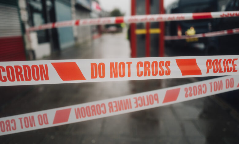 Police white and red cordon tape separating the crime scene.