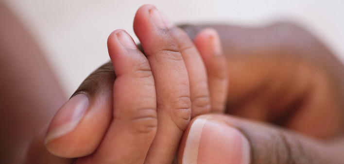 Mother holds baby's hand. Close-up