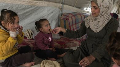 A mother in Gaza cares for her children in a temporary shelter.
