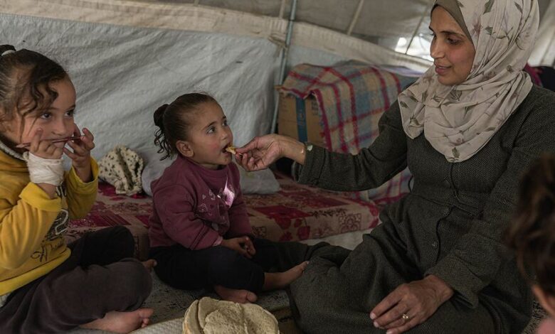 A mother in Gaza cares for her children in a temporary shelter.
