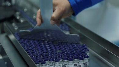 An employee collects vials of the R21 malaria vaccine afer they are labelled inside a lab at the Serum Institute of India