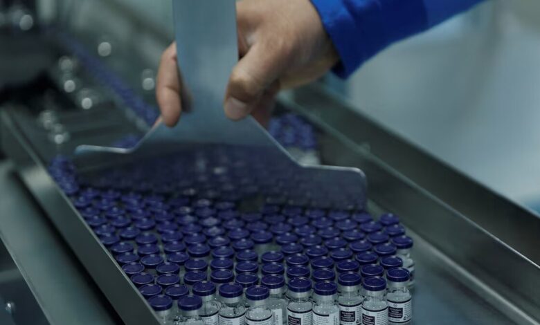 An employee collects vials of the R21 malaria vaccine afer they are labelled inside a lab at the Serum Institute of India