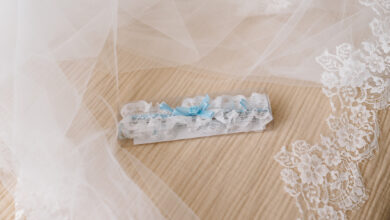 White and blue bridal garter belt on the bed before the wedding, next to the veil.