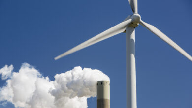 A wind turbine with emissions from a coal fired power station in Amsterdam, Netherlands.