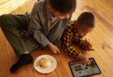 Two boys with burgers playing on the iPad