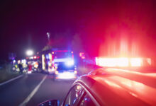 Red flashing light on ambulance car while responding at traffic accident at night