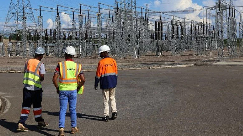 Electricity Supply Corporation of Malawi workers walk through a power substation that helps transmit and distribute electricity to homes and businesses.