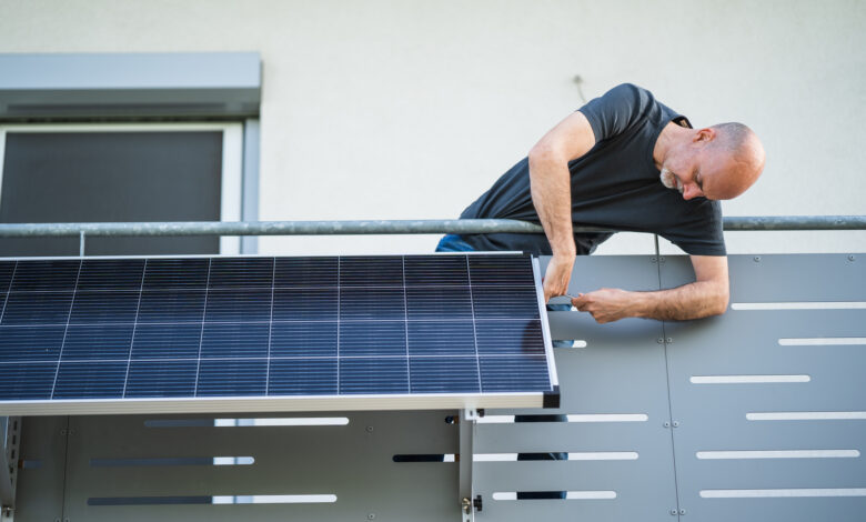 man mounting solar panel on balcony