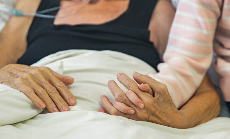 cancer patient with daughter who hold her hands