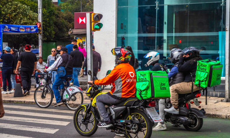 Didi Food and Uber Eats delivery drivers on motorcycles in the streets of Mexico City