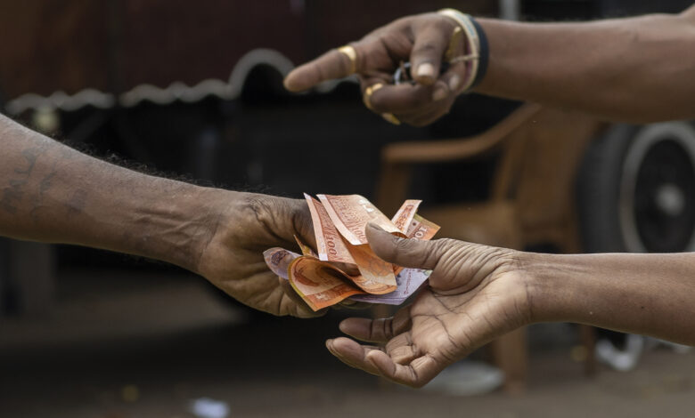 A Person Hands Over Sri Lankan Rupee Banknotes