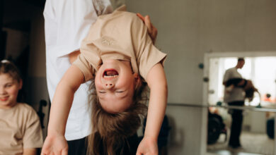 Father holding carefree daughter at home