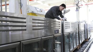 worker injecting refrigerant into freezers on a production line at a kitchen utensils manufacturer in Binzhou, Shandong province.