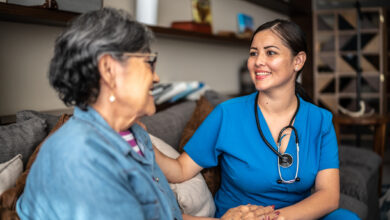 Young nurse woman talking with senior patient woman at nursing home