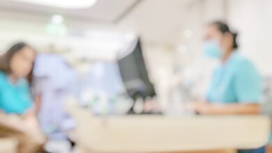 Blur abstract background of patients register at reception desk in hospital. Blurry nurse receptionists taking care new customers in medical clinic. Defocus reception area with worker. Healthcare concept.